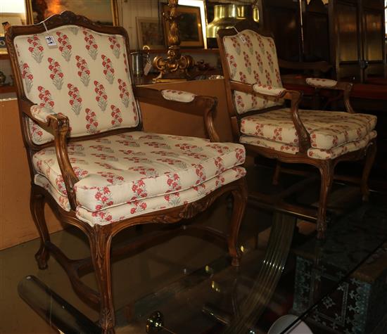 A pair of French carved walnut floral striped upholstered fauteuils, H. 3ft 2in.
